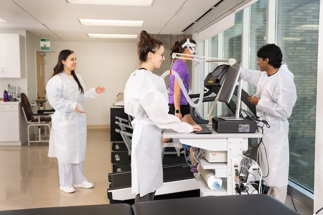 Falk College students observing a person walking on a treadmill.